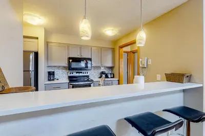 a kitchen with a counter with stools in it at Montezuma Magic in Keystone
