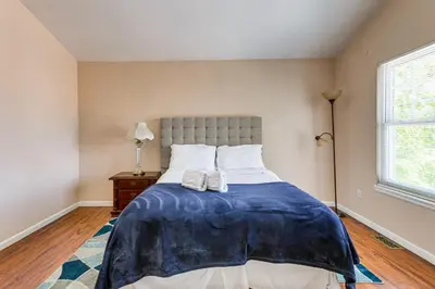 a bedroom with a bed with a blue blanket on it at 15 Mi to Downtown Denver Home with Yard and Patio in Aurora