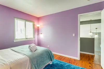 a purple bedroom with a bed and a window at 15 Mi to Downtown Denver Home with Yard and Patio in Aurora