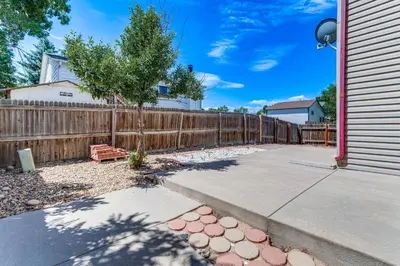a wooden fence next to a sidewalk next to a house at 15 Mi to Downtown Denver Home with Yard and Patio in Aurora