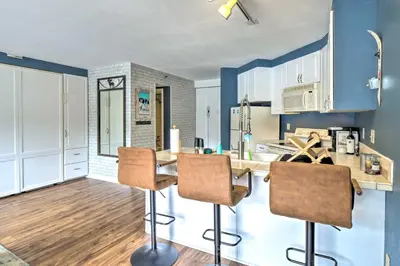 a kitchen with blue walls and a table with chairs at Chic Winter Park Studio with Community Hot Tub in Winter Park