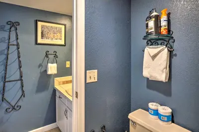 a bathroom with a toilet and a blue wall at Chic Winter Park Studio with Community Hot Tub in Winter Park