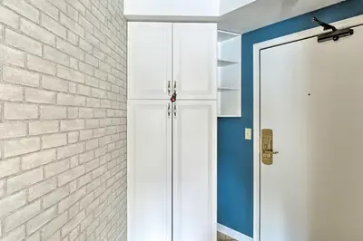 a room with a white door and a brick wall at Chic Winter Park Studio with Community Hot Tub in Winter Park