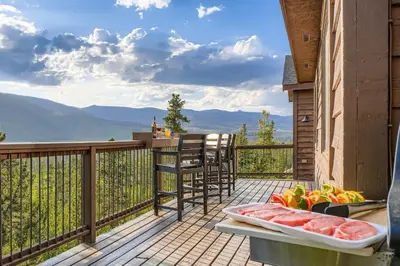a balcony with a bowl of fruit and a plate of meat at Moose Ridge Cabin cabin in Grand Lake