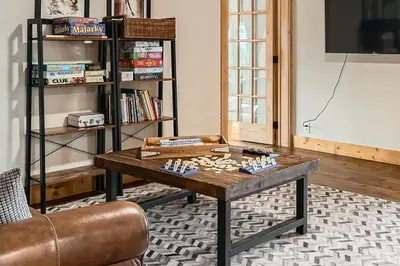 a coffee table in a living room with a book shelf at Moose Ridge Cabin cabin in Grand Lake