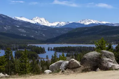 a view of a lake and mountains with rocks at Moose Ridge Cabin cabin in Grand Lake