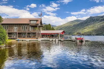 a building on a lake with a dock at Moose Ridge Cabin cabin in Grand Lake