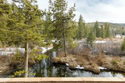 a river in a field with trees and a bridge at 8201 Mill Creek - Private Hot Tub! condo in Dillon