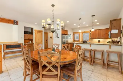 a kitchen and dining room with a wooden table and chairs at 8201 Mill Creek - Private Hot Tub! condo in Dillon