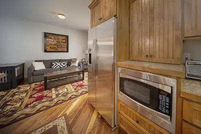 a kitchen with a stainless steel refrigerator and a living room at Bear Trail townhouse in Winter Park