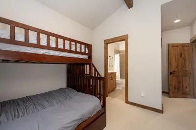 a bedroom with two bunk beds and a bathroom at Bear Trail townhouse in Winter Park
