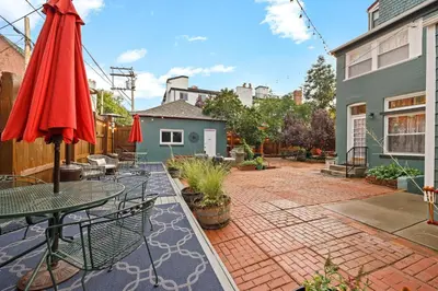 a patio with a table and a red umbrella at Flora House Denver in Denver