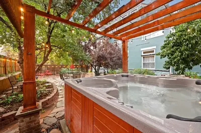 a hot tub in a backyard with a pergola at Flora House Denver in Denver