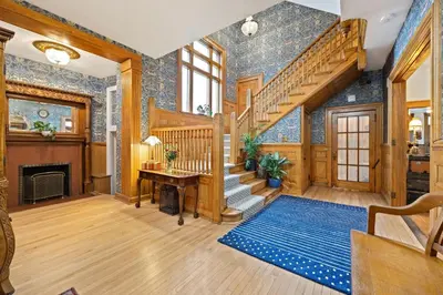 a living room with a staircase and a fireplace at Flora House Denver in Denver