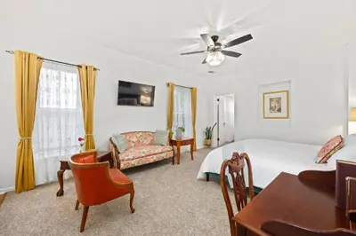 a bedroom with a bed and a couch and a table at Flora House Denver in Denver
