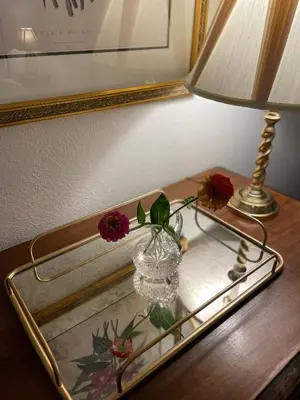 a table with a lamp and a glass vase on a table with a mirror at Flora House Denver in Denver