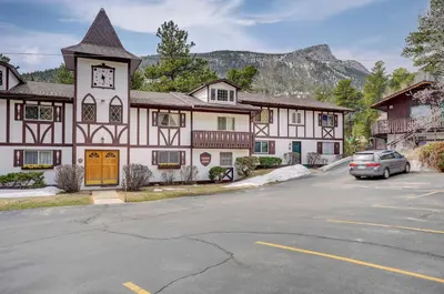 a building with a car parked in a parking lot at Fall River Casita in Estes Park