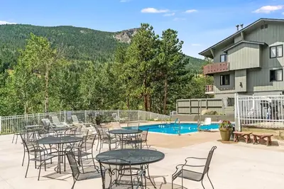 a patio with tables and chairs next to a pool at Fall River Casita in Estes Park