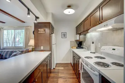 a kitchen with a white counter top and wooden cabinets at Fall River Casita in Estes Park