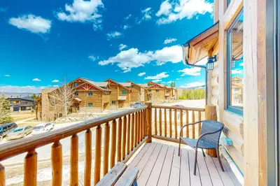 a deck with a chair and a view of a house at Pine Peak in Fraser