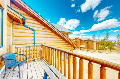 a blue chair sitting on a wooden deck with a house at Pine Peak in Fraser