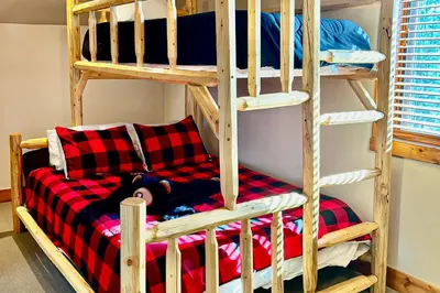 a bunk bed with a red and black checkered blanket at Pine Peak in Fraser