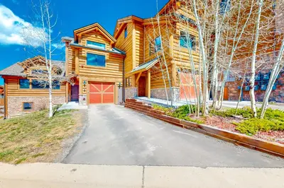 a log home with a driveway in front of it at Pine Peak in Fraser