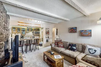a living room with a couch and a kitchen at Hi Country Haus Hideaway in Winter Park