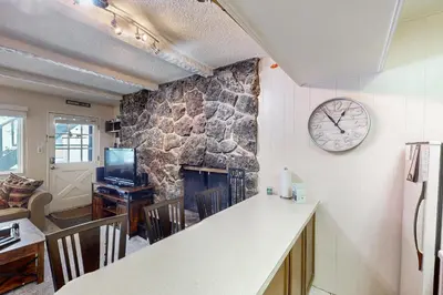 a kitchen with a fireplace and a clock on the wall at Hi Country Haus Hideaway in Winter Park