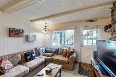a living room with a couch and a tv at Hi Country Haus Hideaway in Winter Park