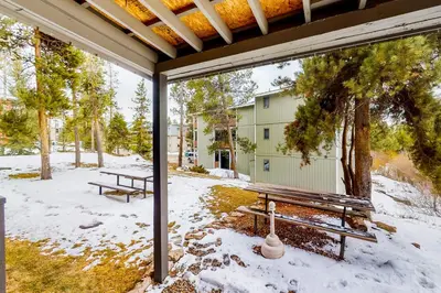 a screened in porch with two benches in the snow at Hi Country Haus Hideaway in Winter Park
