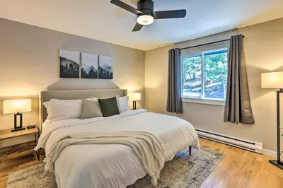 a bedroom with a bed with a ceiling fan and a window at Scenic Conifer Getaway with Game Room and Hot Tub! in Conifer