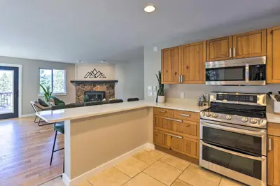 a kitchen with wooden cabinets and a stove top oven at Scenic Conifer Getaway with Game Room and Hot Tub! in Conifer