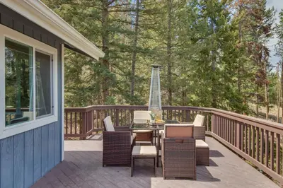 a patio with a table and chairs on a deck at Scenic Conifer Getaway with Game Room and Hot Tub! in Conifer