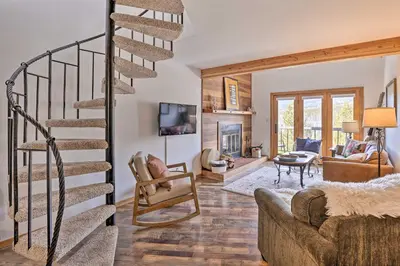 a living room with a spiral staircase and a fireplace at Private Balcony and Resort Perks Silverthorne Condo in Silverthorne