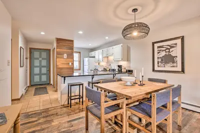 a kitchen and dining room with a wooden table and chairs at Private Balcony and Resort Perks Silverthorne Condo in Silverthorne