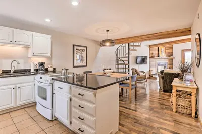 a kitchen with white appliances and a living room at Private Balcony and Resort Perks Silverthorne Condo in Silverthorne