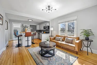 a living room with a couch and a table at Charming Vintage Cottage with Hot Tub & Free Bikes! in Fort Collins