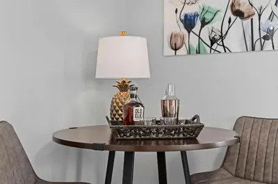 a table with a lamp and two bottles on it at Charming Vintage Cottage with Hot Tub & Free Bikes! in Fort Collins