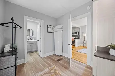 a living room with white walls and a hallway with a kitchen at Charming Vintage Cottage with Hot Tub & Free Bikes! in Fort Collins