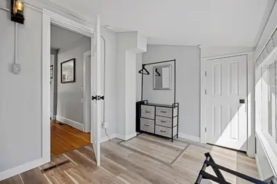 a hallway with white walls and a dresser at Charming Vintage Cottage with Hot Tub & Free Bikes! in Fort Collins