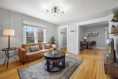 a living room with a couch and a table at Charming Vintage Cottage with Hot Tub & Free Bikes! in Fort Collins