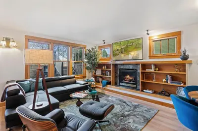 a living room with a couch and a fireplace at Sleek Condo - Near Park, Poudre River and Old Town in Fort Collins