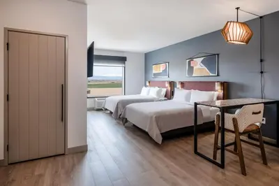 a hotel room with two beds and a table at Atwell Suites Denver Airport - Tower Road by IHG in Denver