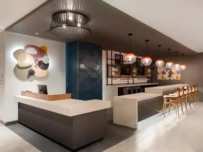 a restaurant with a bar with stools and tables at Atwell Suites Denver Airport - Tower Road by IHG in Denver