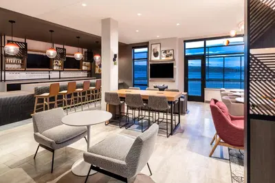 a restaurant with a bar with chairs and tables at Atwell Suites Denver Airport - Tower Road by IHG in Denver