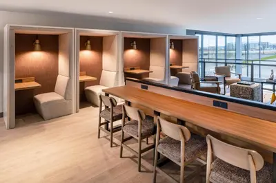 a lobby with a long bar and chairs at Atwell Suites Denver Airport - Tower Road by IHG in Denver