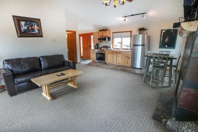 a living room with a leather couch and a table at Rocky Mountain Retreat 1B by Rocky Mountain Resorts in Estes Park