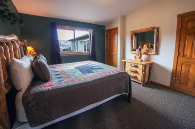 a bedroom with a bed and a mirror and a window at Rocky Mountain Retreat 1B by Rocky Mountain Resorts in Estes Park