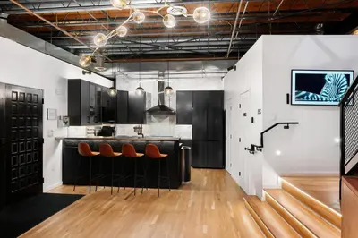 a kitchen with a bar with stools at Hotel Residential of Denver in Denver